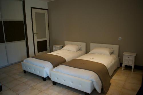 deux lits côte à côte dans une pièce dans l'établissement Domaine du Clos Pallacien, à Paillé