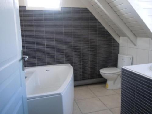 a bathroom with a white tub and a toilet at VILLA D'ALICE 1 in Sainte-Anne
