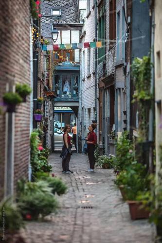 two women walking down a street in an alley at Appartement atypique - coeur historique de Liège in Liège