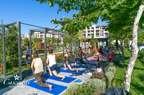 a group of people doing yoga in a park at Cascadas Family Resort in Sunny Beach