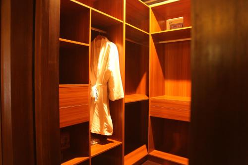 a wooden closet with a robe hanging in it at Shanghai Daoli one step garden(PVG&International Resort) in Shanghai