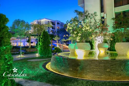 a group of vases sitting in a park at night at Cascadas Family Resort in Sunny Beach