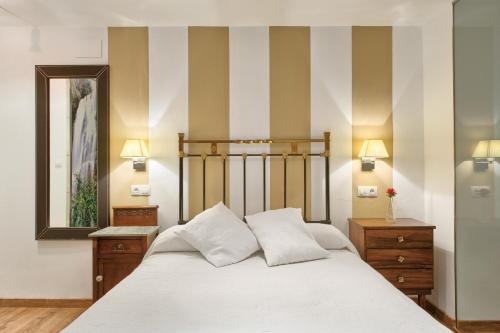 a bedroom with a bed and a striped wall at El Molín de Petra in Valbucar