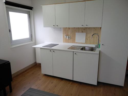 a kitchen with white cabinets and a sink and a window at Chalet Fiocco di neve, Passo del Tonale in Passo del Tonale