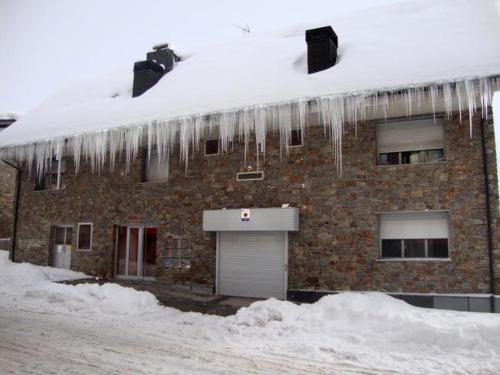 ein Gebäude mit Eiszapfen vom Dach in der Unterkunft ARAe 4 CONFORT in Pas de la Casa