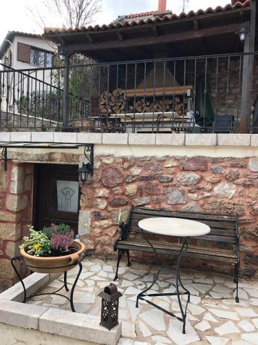 a patio with a table and a bench and a fireplace at Proselinos in Dhimitsana