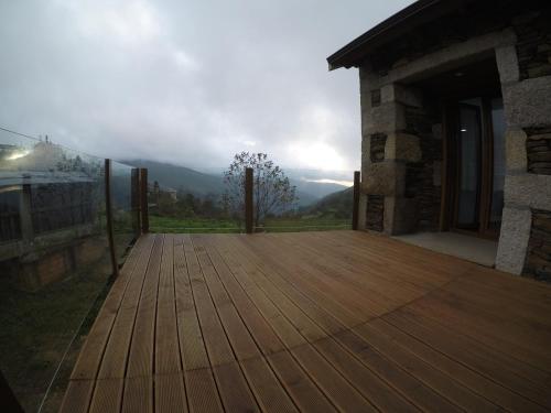 a wooden deck with a view of the mountains at Refúgio dos Macedos in Bilhó