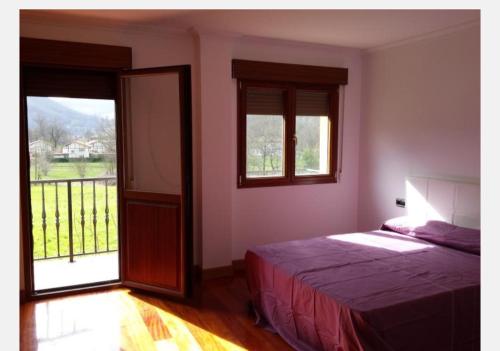 um quarto com uma cama e uma grande janela em Casa independiente em Liendo