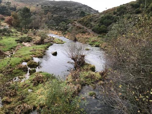 a river in a field next to a mountain at Refúgio dos Macedos in Bilhó