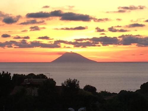 a view of a mountain in the ocean at sunset at Case Vacanze Sangeni in Capo Vaticano