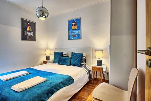リスボンにあるSão Lazaro Apartmentのベッドルーム1室(大型ベッド1台、青いシーツ、椅子付)