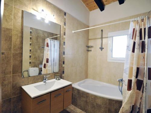 a bathroom with a tub and a sink and a bath tubermottermott at Pyramid City Apartments in Agios Spyridon Corfu