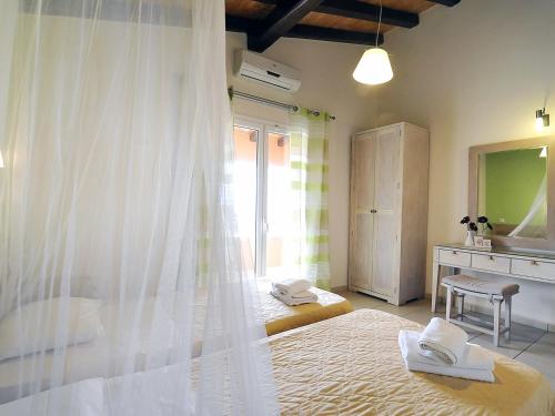 a bedroom with a bed with a white mosquito net at Pyramid City Apartments in Agios Spyridon Corfu