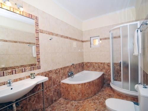 a bathroom with a tub and a sink and a toilet at Pyramid City Apartments in Agios Spyridon Corfu