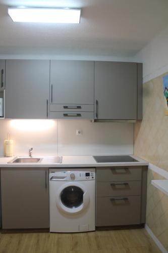 une cuisine avec une machine à laver et un évier dans l'établissement Apartamento Victoria, à Vilamoura
