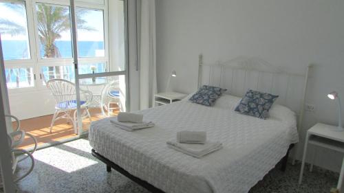 um quarto com uma cama com duas toalhas em Apartamento 1º linea playa Torrenueva, Motril, Granda em Torrenueva