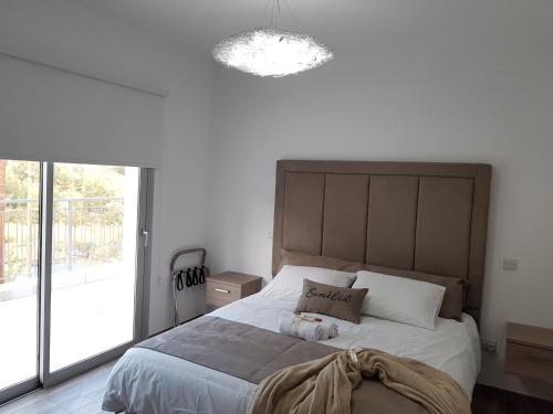 a bedroom with a large bed with a large window at Evmelia Kakopetria Suites in Kakopetria