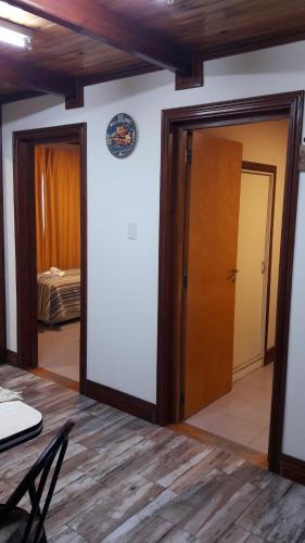 a room with two doors and a table and a bed at Cabañas Oyikil in El Calafate