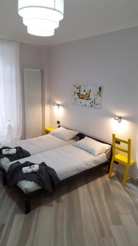 sypialnia z 2 łóżkami i żółtym krzesłem w obiekcie Ana's Place Torino 1 w Turynie