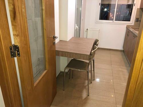a kitchen with a wooden table and chairs next to a door at Appartement S+1 Jardin De Carthage in Tunis
