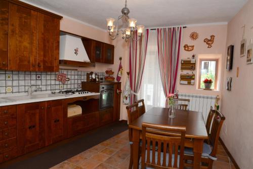 a kitchen with wooden cabinets and a table with chairs at Roccaraso Relais in Roccaraso