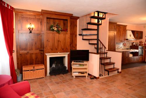 a living room with a spiral staircase and a fireplace at Roccaraso Relais in Roccaraso