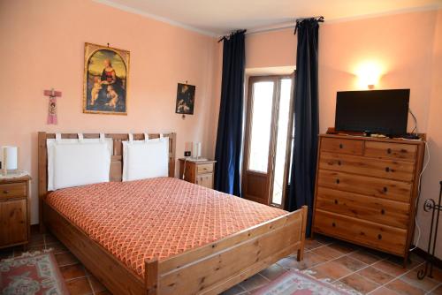 a bedroom with a bed with a television and a dresser at Roccaraso Relais in Roccaraso