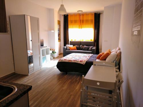 een kleine woonkamer met een bank en een woonkamer bij Apartamento Domingo Lozano in Málaga