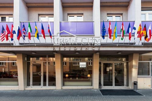 a building with a bunch of different flags on it at Urpí­n City Residence in Banská Bystrica