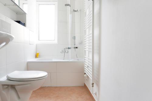 uma casa de banho branca com um WC e um lavatório em Apartment BLISSE Large & Cozy Family & Business Flair welcomes you - Rockchair Apartments em Berlim