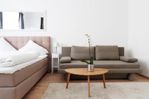 a living room with a couch and a table at Apartment BLISSE Large & Cozy Family & Business Flair welcomes you - Rockchair Apartments in Berlin