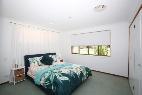 sypialnia z łóżkiem i oknem w obiekcie BILL'S w mieście Coffs Harbour