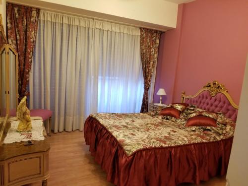 um quarto com uma cama grande e uma cabeceira vermelha em Depto sobre Peatonal San Martin em Mar del Plata