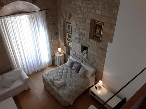 a bedroom with a bed and a stone wall at Case Brizi Assisi in Assisi