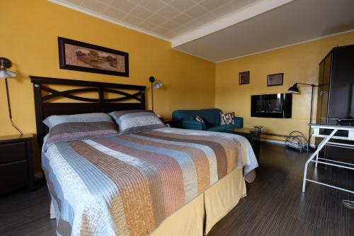 a hotel room with a bed and a tv at Motel Canadien in Trois-Rivières