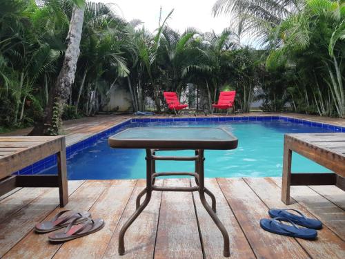 a table and chairs next to a swimming pool at Hostal Hilltop Sapzurro in Zapzurro