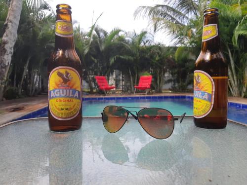 two bottles of beer and a pair of glasses on a table at Hostal Hilltop Sapzurro in Sapzurro