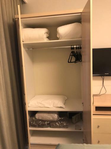 a closet with white pillows and a bed at Flat Partic Hotel Jurere Beach Village in Florianópolis