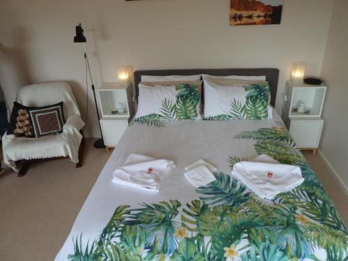 een slaapkamer met een groot bed met een tropische sprei bij Murrindindi in Kallista