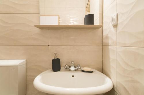 a bathroom with a white sink and a toilet at Cherry Apartment Arena in Belgrade