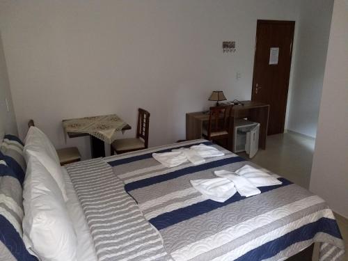 a bedroom with a bed with towels on it at Hotel Ametista in Ametista do Sul