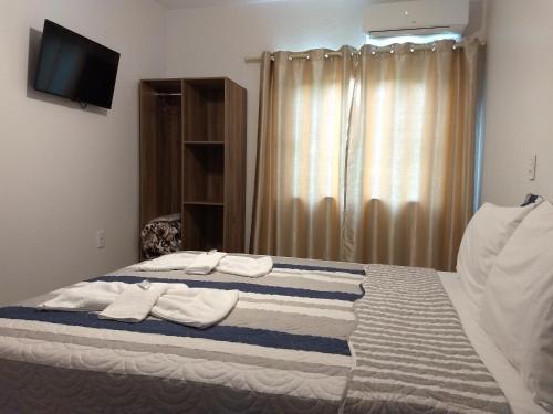 a bedroom with a bed with towels on it at Hotel Ametista in Ametista do Sul