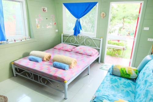 a room with a bed with pillows and a couch at A Houses Homestay in Nakhon Ratchasima
