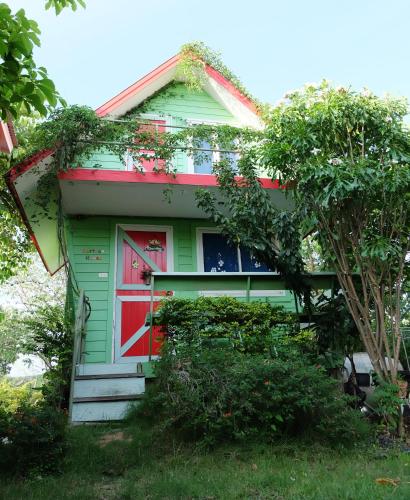a green and red house with a red door at A Houses Homestay in Nakhon Ratchasima