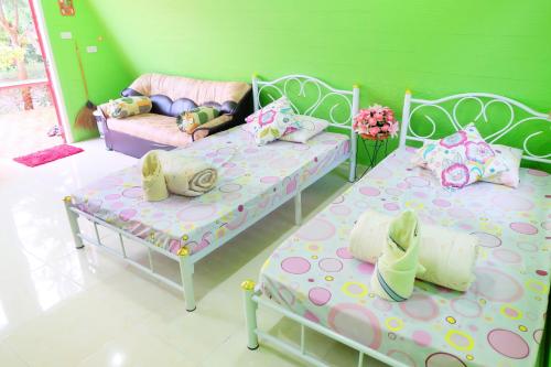 a room with two beds and a couch at A Houses Homestay in Nakhon Ratchasima