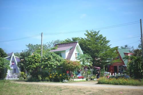a group of houses with flowers in the yard at A Houses Homestay in Nakhon Ratchasima