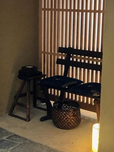 a wooden bench and a stool in a room at Auberge AZABU in Kyoto