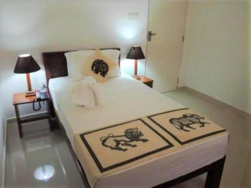 sypialnia z dużym łóżkiem i 2 szafkami nocnymi w obiekcie Candila Hotel & Sports Club w mieście Habarana