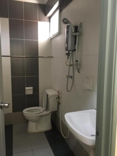 uma casa de banho com um WC, um lavatório e um chuveiro em Hotel Morning Glory em Kudat