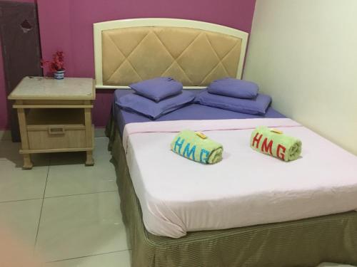 two beds in a room with two pillows on them at Hotel Morning Glory in Kudat